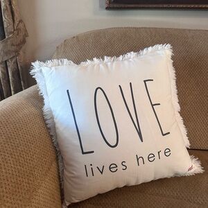 Decorative White Pillow with 'Love Lives Here' Design